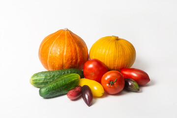 Colorful composition of fresh vegetables on a white background. Pumpkins, tomatoes and cucumbers on a white background. Isolated. Harvesting in autumn