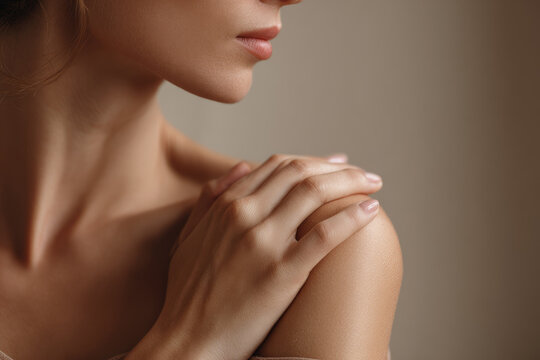 Close up of bare shoulder delicate hand touching smooth skin soft natural light healthy complexion feminine beauty gentle serene relaxation wellness skincare