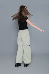 A girl spins playfully, causing her hair to flow freely in a minimalist studio setting. Capturing spontaneous moments emphasizes the carefree spirit essential to healthy child development.