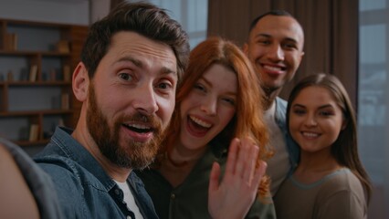 Fototapeta premium Webcam web camera view Caucasian man inviting friends making selfie together smiling posing four multiethnic people buddies men women group photo looking at smartphone laughing funny record video