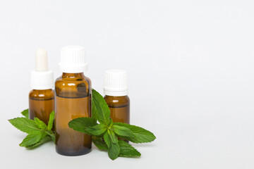 Natural Mint Essential Oil in a Glass Bottle. organic cosmetics with herbal extracts of mint on...