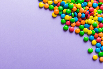 Obraz premium Mixed collection of colorful candy, on colored background. Flat lay, top view. frame of colorful chocolate coated candy