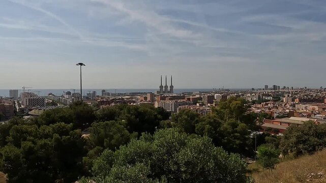 Badalona, Spain-23 August 2024. Panoramic view of the energy towers in Badalona, Spain, from a nature park. The harmony between nature and industry captured from a park overlooking three chimneys.