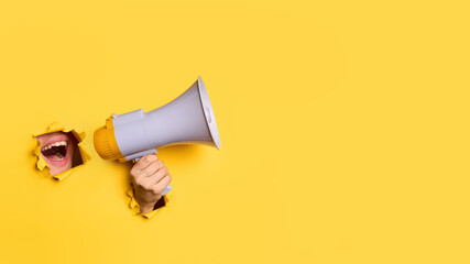 Female mouth screaming in megaphone to copy space