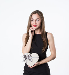 Beautiful woman with a heart-shaped gift in her hands. A gift for a romantic date. Isolated on white