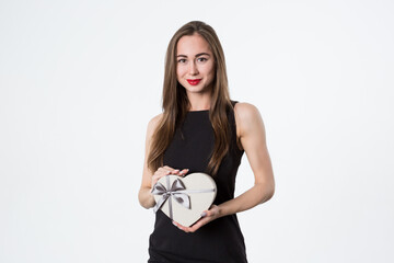 Beautiful woman with a heart-shaped gift in her hands. A gift for a romantic date. Isolated on white