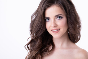 Portrait of beautiful cute woman close-up in studio on white background, natural makeup, wavy hairstyle.