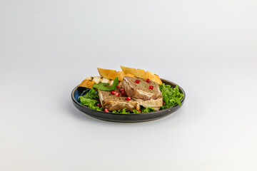 A delectable display of gourmet pate served on lettuce leaves, accompanied by slices of fresh baguette, and garnished with vibrant pomegranate seeds.