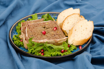 A delectable display of gourmet pate served on lettuce leaves, accompanied by slices of fresh baguette, and garnished with vibrant pomegranate seeds.