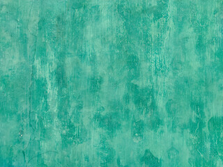 A vibrant, abstract-like close-up of a weathered wall with a rich, uneven turquoise-green patina....
