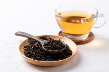 Dried black tea leaves and hot tea on white background, Healthy herbal drink