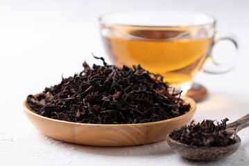 Dried black tea leaves and hot tea on white background, Healthy herbal drink