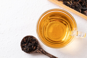 Top view of black tea in cup glass with dried tea leaves on white background, Healthy herbal hot...