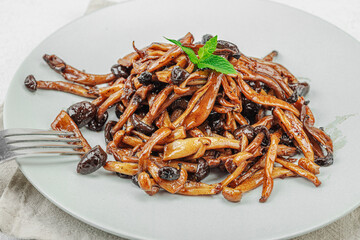 Fried Shimeji mushrooms with spices and herbs on a trendy plate. Vegan lifestyle concept