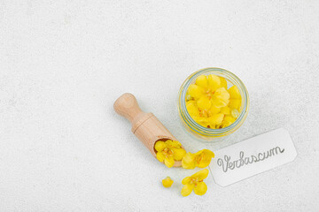 Fresh Verbascum flowers in a small jar with name tag. Alternative medicine