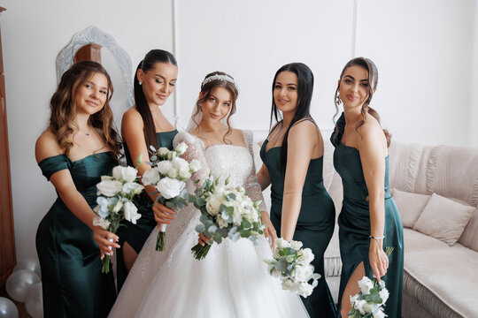 Bridal party gathers in elegant green dresses for a joyful wedding celebration in a home setting - Powered by Adobe