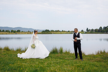 Couple shares a romantic moment by the lake during their outdoor wedding ceremony at sunset