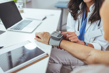 Fototapeta premium Doctor Measuring Patient's Blood Pressure During a Medical Consultation in Office