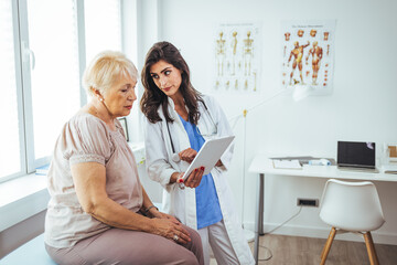 Obraz premium Doctor Discussing Medical Treatment With Elderly Patient During Consultation in Clinic