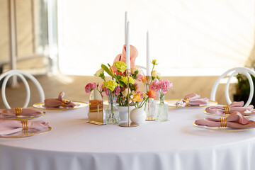Table decor in a restaurant with beautiful vases of pink anthurium flowers, roses and carnations. Celebration, wedding