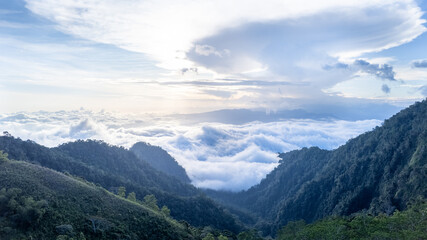 Fototapeta premium Dramatic view of a valley flanked by two hills, with thick clouds and hidden sunlight, creating a moody, atmospheric landscape perfect for nature and travel projects. 