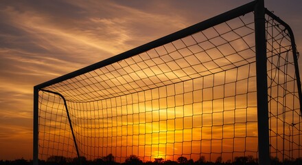 Football net silhouette filled with sunrise sky