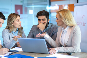 Business people concerned and thoughtful while reviewing company financial status and planning next steps