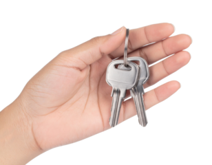 A hand holding two metal keys on a ring against a black background, symbolizing access and security.