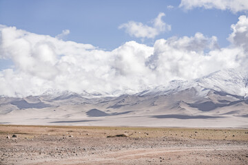 Landscape in the mountains of Tajikistan in Pamir with snow, glaciers and rocks, panorama of mountains in cloudy weather for the background, nature in the highlands of Tien Shan