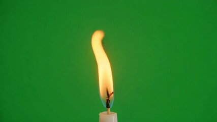 A single candle flame burns brightly against a vibrant green background, symbolizing hope and light. - Powered by Adobe
