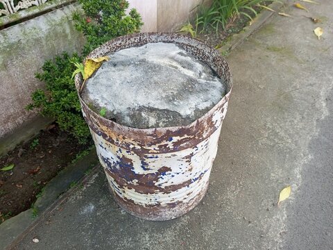 Weathered and Rusty Oil Drum with Concrete