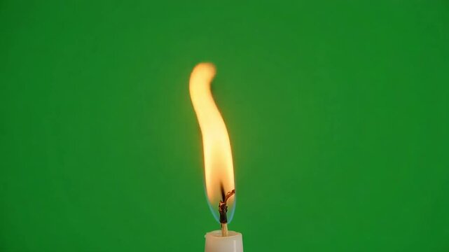 A single candle flame burns brightly against a vibrant green background, symbolizing hope and light.