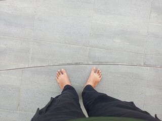 First Person View of A Man Standing Barefoot on a Floor