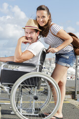 Naklejka premium loving couple in wheelchair walking outdoors