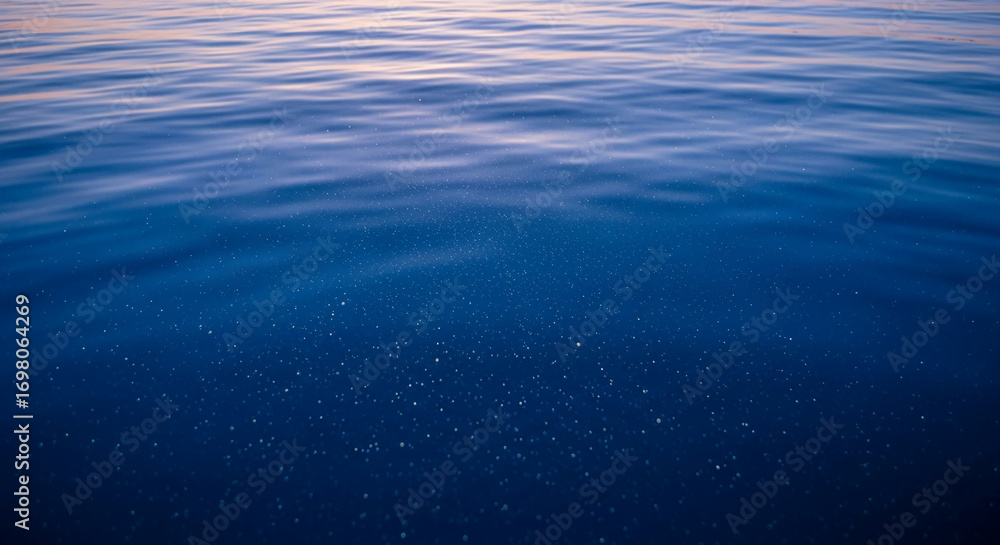 Poster blue water surface texture with subtle waves and small particles, creating a tranquil and serene sce