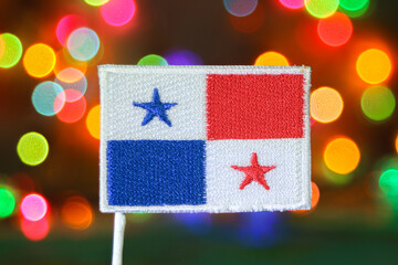 Panama embroidered flag with colorful bokeh fireworks lights in background, symbolizing Christmas and New Year celebration with patriotic spirit.