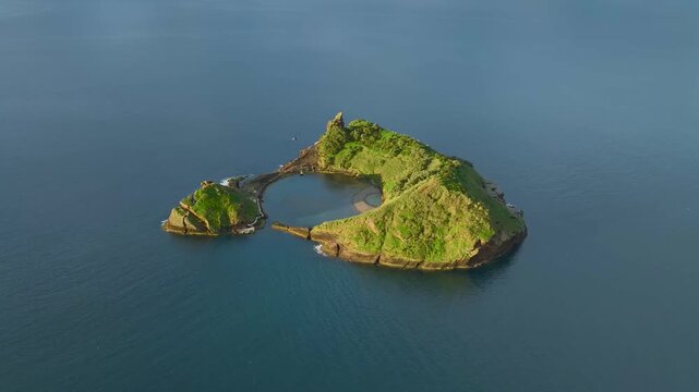 Aerial view of the volcanic islet of Vila Franca do Campo, a vibrant green jewel surrounded by the deep blue Atlantic, Vila Franca do Campo, Azores, Portugal.