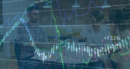 Collaborating trio reviewing stock market charts in coworking space, with laptops and coffee mugs