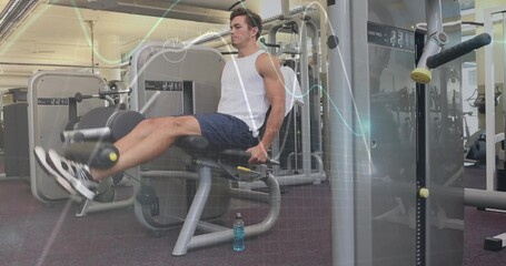 Fit man in athletic wear extending legs on leg extension machine at gym, with bottle