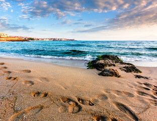 sunrise on a sandy town beach in mellow season. beautiful and warm weather on the shores of black sea. sozopol coast in morning light