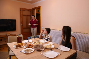Woman returns with two bowls of food to festive holiday table.