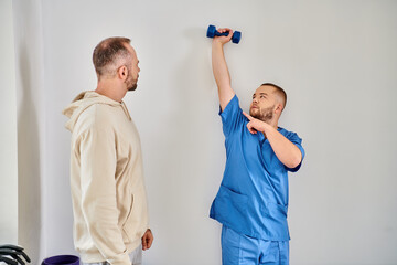 Patient engaged in rehabilitation with guidance from his physiatrist