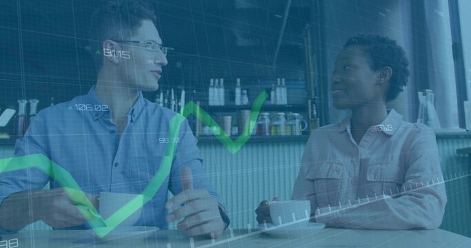 Discussing business-casual duo analyzing market data at cafe, with white mugs, stock charts overlay