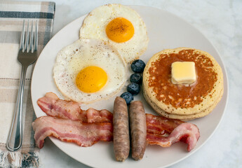 fried eggs wih pancakes and sausages