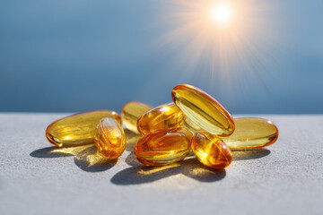 
Vitamin D pills or capsules with fish oil and omega 3 fats on a clean background back-lit by the sun