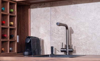 Modern kitchen corner featuring sleek faucet, coffee maker, and organized wine storage in a stylish setting