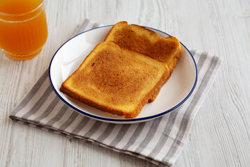 Homemade American Cinnamon Toast with Butter and Orange Juice, side view.