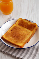 Homemade American Cinnamon Toast with Butter and Orange Juice, side view.