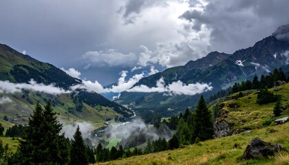 Obraz premium Mountain valley vista with dramatic clouds, peaks shrouded in mist, and lush green foliage