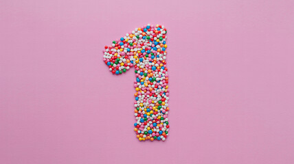 Colorful Number One Made of Sprinkles on Pink Background